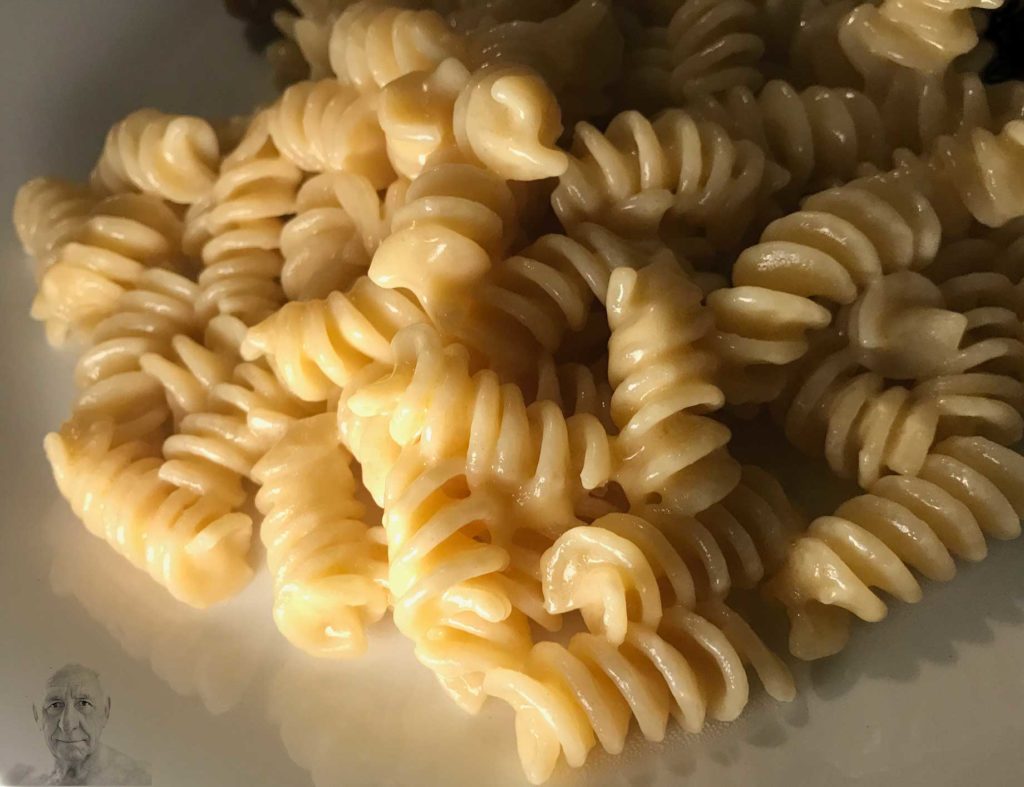 A plate of noodles for Raymond Federman, on Noodle Day for Raymond Federman, with a picture of Ray watching out from the corner